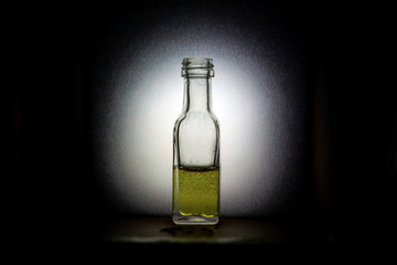 A picture of the small vintage glass bottle with a colorful liquid inside. Looks like some medicine, some alcohol or potion. 
