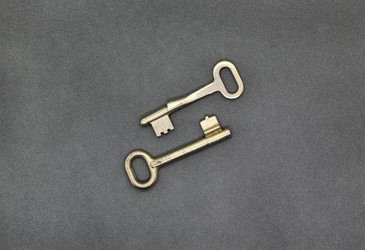 Two keys on gray paper background, close up