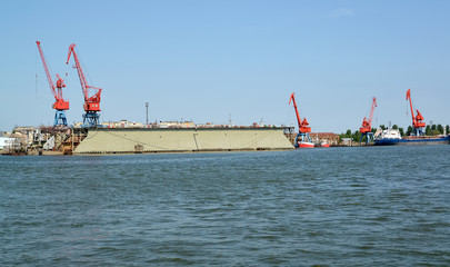 Portal cranes and floating ship dock from the sea. Kaliningrad region