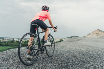 Fototapeta premium Young woman cyclist riding mountain bike on forest trail