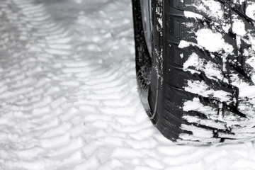 Snow tire and snowy road close up.