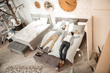 Obraz na płótnie Canvas Interested couple examining quality of mattress for their future life