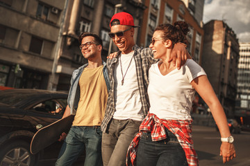 Group of friends hangout at the street.They embrace each other and walks around at the city...