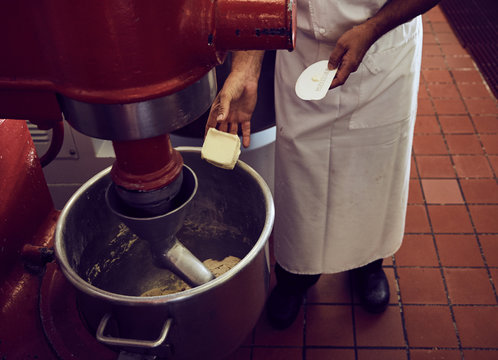 Chef adding butter to large mixer