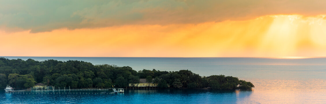 Panorama of dramatic sunrise over Roatan Island in the Caribbean.