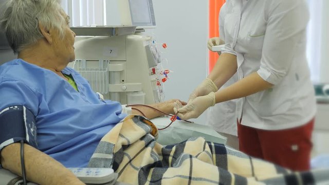 Hemodialysis center. Connecting a person to the apparatus of an artificial kidney. Blood sampling for analysis from the blood purification system.