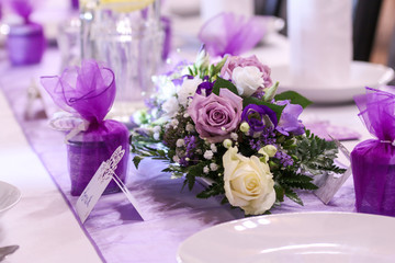 A picture of a nice bouquet of flowers. It is a wedding flower for the bride. Lies on the table dedicated for the lunch. 