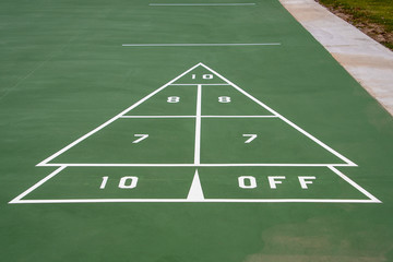 white and green painted shuffleboard game sign on pavement
