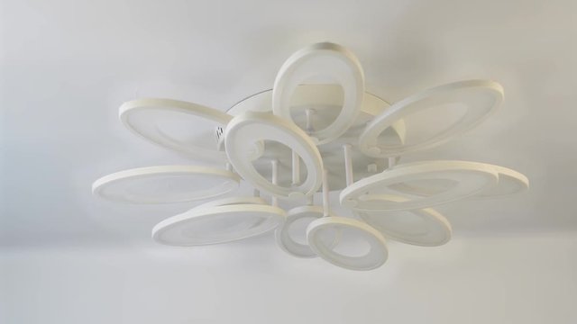 LED chandelier in the shape of petals on a white stretch ceiling