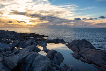 Beautiful rocky Atlantic Ocean Coast during a vibrant sunset. Taken at Cow Head, Newfoundland, Canada.