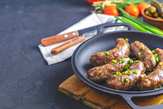 Fried sausage in a frying pan, with herbs and spices