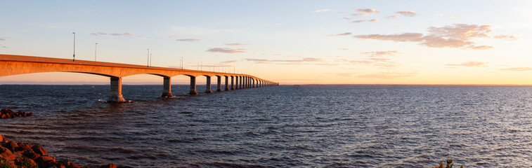 Panoramic view of Confederation Bridge to Prince Edward Island during a vibrant sunny sunrise. Taken in Cape Jourimain National Wildlife Area, New Brunswick, Canada.