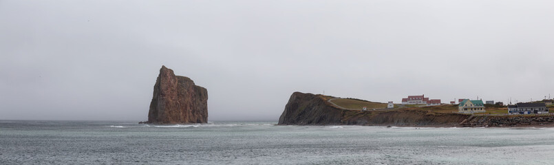 Fototapeta na wymiar Panoramic view of a Rocky Coast on the Atlantic Ocean during a cloudy day. Taken in Perce, Quebec, Canada.