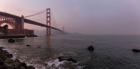 Beautiful view of Golden Gate Bridge during a cloudy sunset. Taken in San Francisco, California, United States.