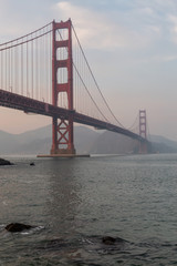 Beautiful view of Golden Gate Bridge during a cloudy sunset. Taken in San Francisco, California, United States.