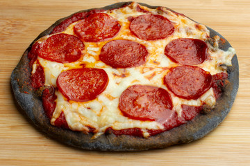 Creative pizza on black dough posted on blackboard.