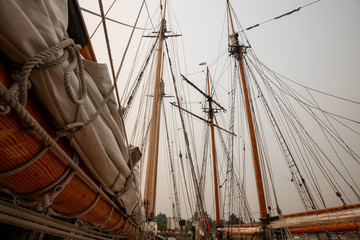 Fototapeta premium Port Hardy, Vancouver Island, BC, Canada - August 20, 2018: Wooden sailboat parked at a marina during a foggy summer day.