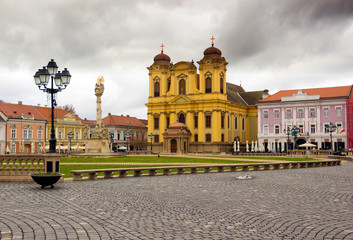 Romania - Timisoara - Wide view of old classical buildings and baroque roman-catholic St. George's cathedral on the sides of Union square (piata Unirii)