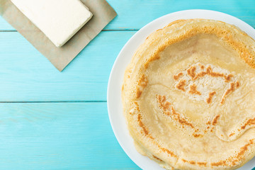 Homemade pancakes blini with flour, eggs and butter on blue wooden background. Russian Maslenitsa, Shrove tide, pancake week, carnival, pancake day.