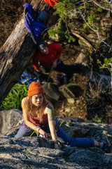 Squamish, BC, Canada - January 15, 2019: Female Rock climber climbing on the edge of the cliff during a sunny winter sunset.