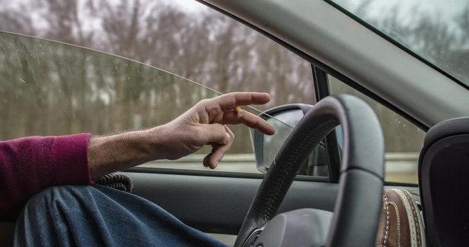 side view of man driving with cigarette, filmed in 4K RAW
