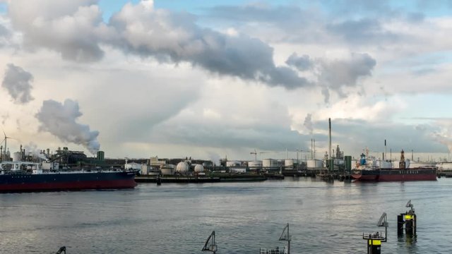 Timelapse of oil terminals, pipelines, chimneys, emissions, clouds in Port of Rotterdam Europoort