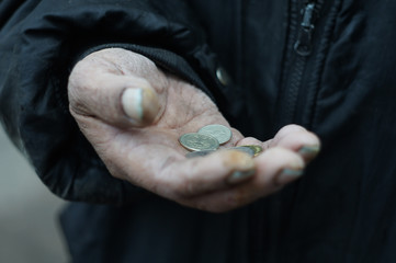 Homeless man holds money in his hands