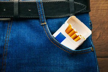 A pack of cigarettes in a pocket of blue jeans