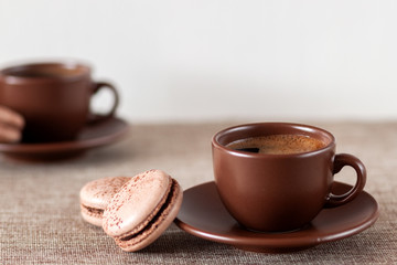 On the table is a cup of coffee with macaroon