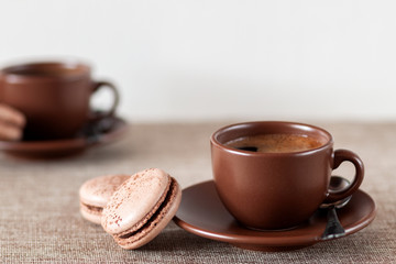 On the table is a cup of coffee with macaroon