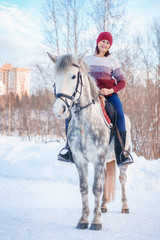 young beautiful woman in winter with beautiful white horse