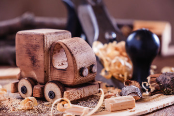 Fototapeta na wymiar Wooden toy truck van car on the carpentry workbench. Hobby diy crafts, making
