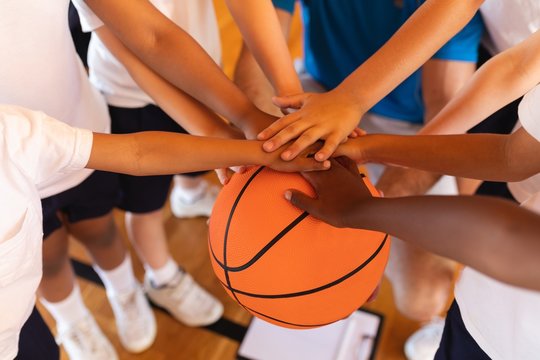 Close-up of Schoolkids forming hand stack on basketball at