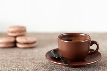 On the table is a cup of coffee with macaroon