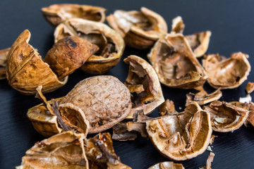 Top view of cracked walnuts shell on wooden background.