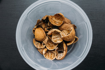 Top view of cracked walnuts shell on wooden background.