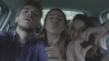 Happy teenage man taking selfie video streaming with couple dancing funny crazy girls while they going on summer holiday party and fun roadtrip concept