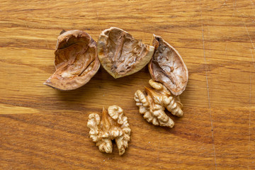 Fototapeta na wymiar Close up of healthy brown walnuts scattered on the wooden table.