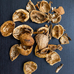 Top view of cracked walnuts shell on wooden background.