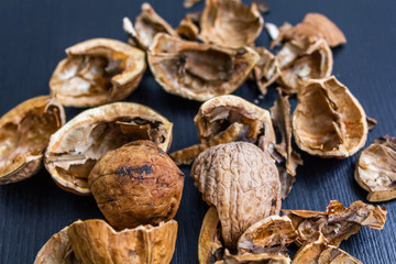 Top view of cracked walnuts shell on wooden background.