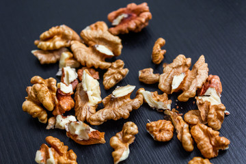 Close up of healthy brown walnuts scattered on the wooden table.
