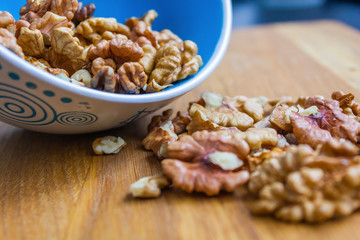Close up of healthy brown walnuts scattered on the wooden table