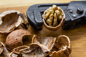 Fresh walnuts on a wooden table with nutcracker.