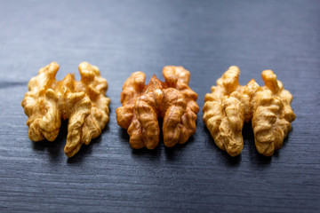 Close up of healthy brown walnuts scattered on the wooden table.