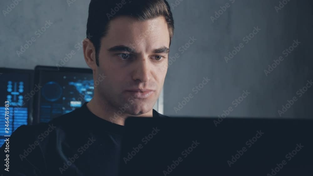 Wall mural developer programmer working on computer in a data center filled with monitor screens. steadicam sho