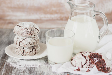 Handmade chocolate cookies, glass and jug with milk, blurred background