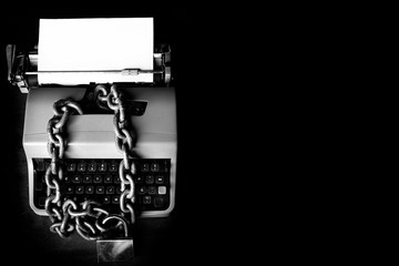 Information censorship - Typewriter locked with a chain - obrazy, fototapety, plakaty