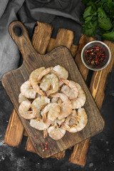 Raw tiger shrimp on the wood board on a dark background