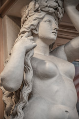 Portrait of balcony support statue of young and naked sensual Roman renaissance era women in Vienna, Austria, details, closeup