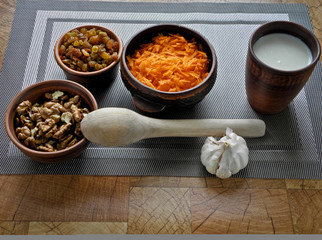 Healthy food in a brown clay dish with a wooden spoon on the table.